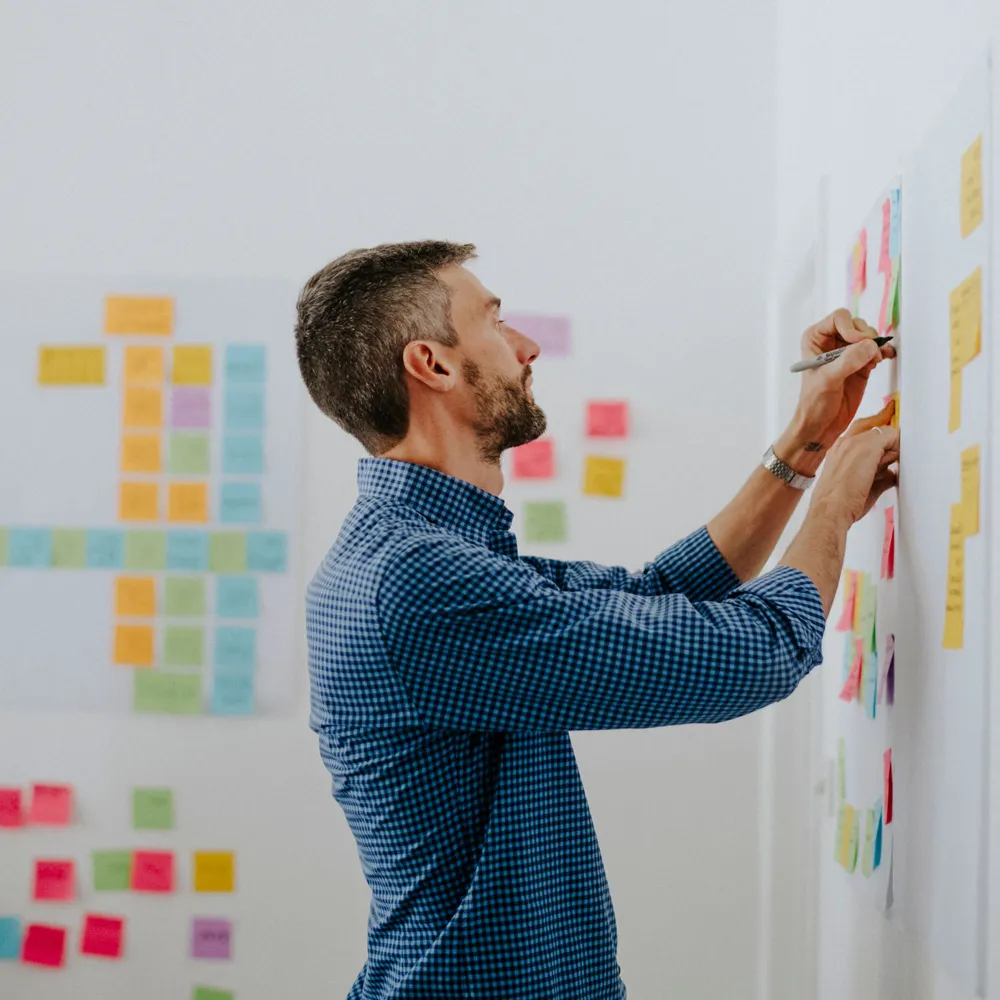 Etienne writing on sticky notes on a workshop wall